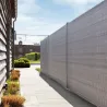 Brise-vue rouleau PVC gris anthracite posé sur clôture panneau rigide